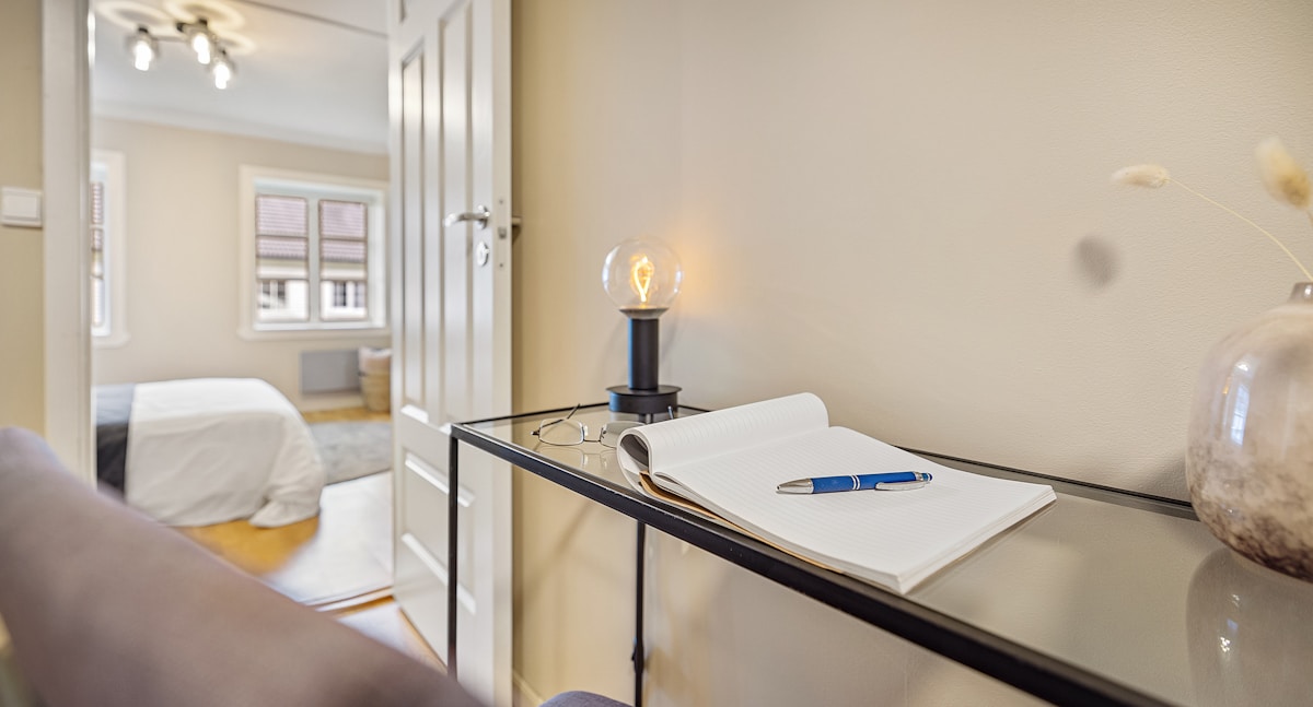 Chambre d'hôtel moderne avec bureau, lampe et fenêtre.