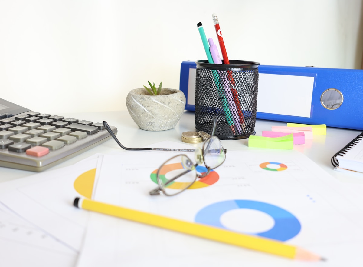 Bureau de travail avec divers articles de papeterie et accessoires.