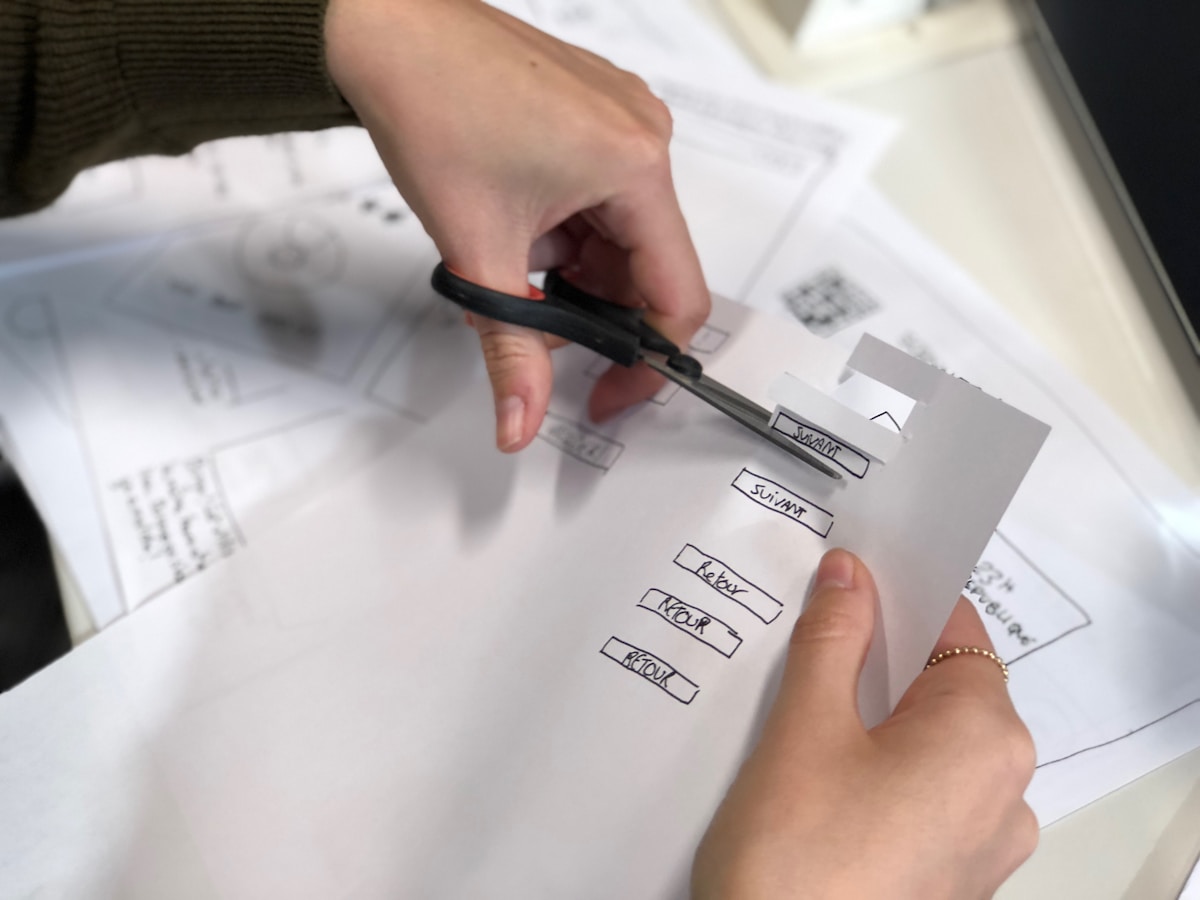 Mains tenant un stylo et remplissant un formulaire avec des options à cocher.