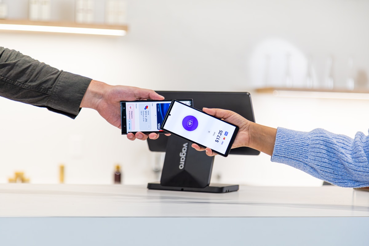 Deux personnes utilisant un terminal de paiement mobile pour effectuer un paiement.