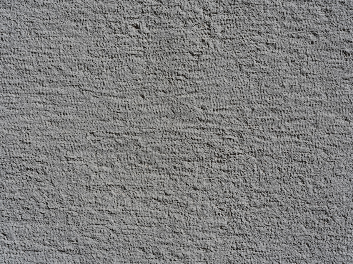 Rough textured gray wall surface with shadows
