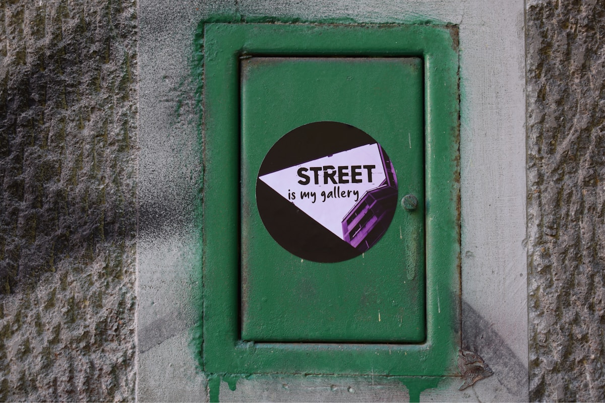 Panneau vert avec texte "Street is my gallery" sur fond noir.