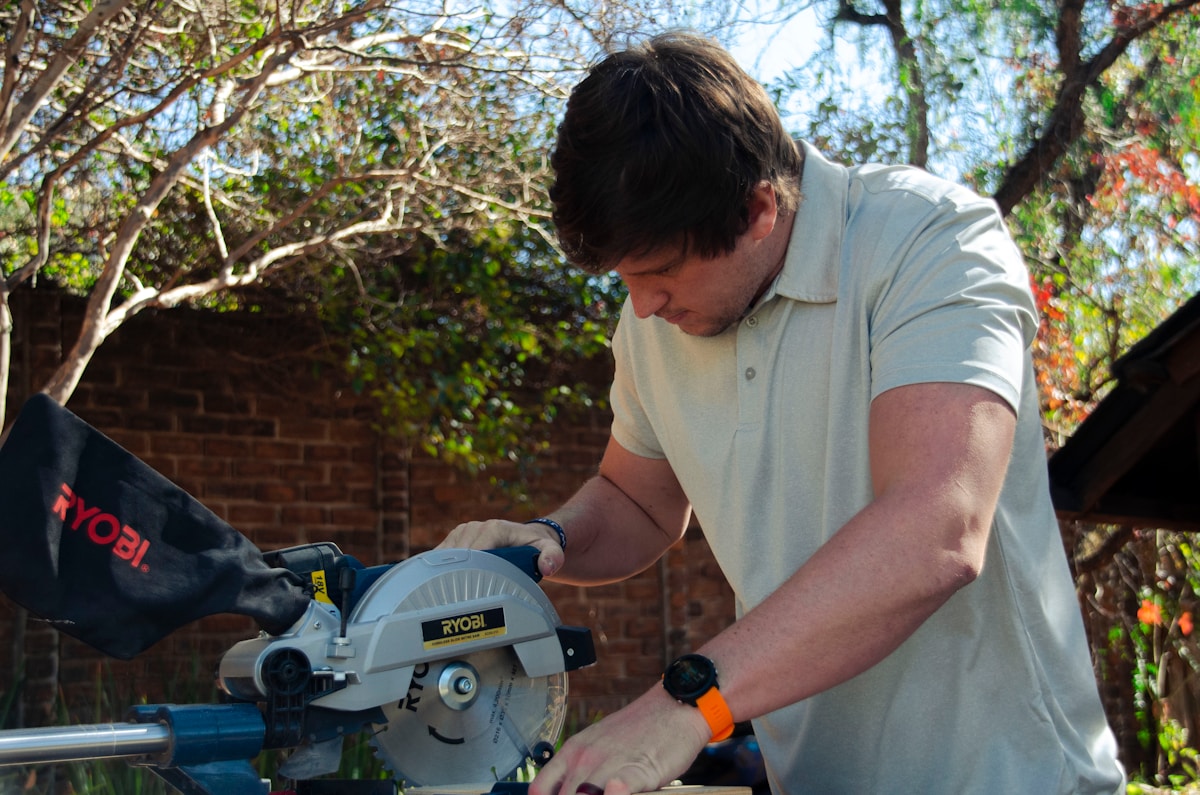 a man using a circular saw to cut a piece of wood