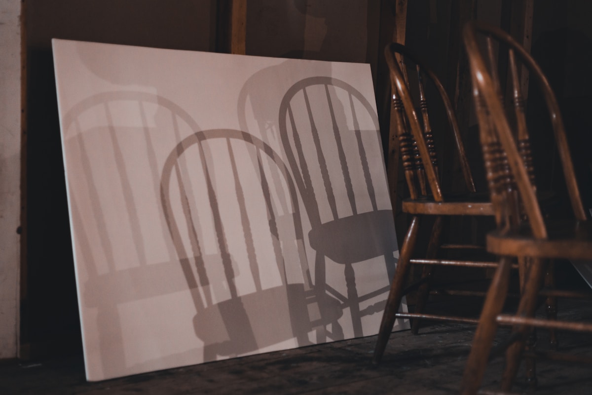 a shadow of two chairs on a canvas