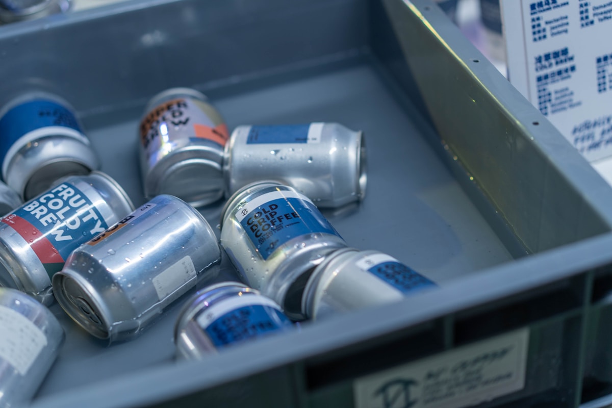Une poubelle métallique remplie de canettes de soda.