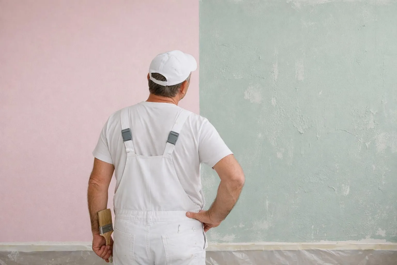 Comparaison côte à côte de deux murs peints montrant la différence de qualité, l'un avec une finition haut de gamme et l'autre avec de la peinture bon marché présentant des défauts, scène de rénovation intérieure avec un peintre professionnel examinant les deux surfaces