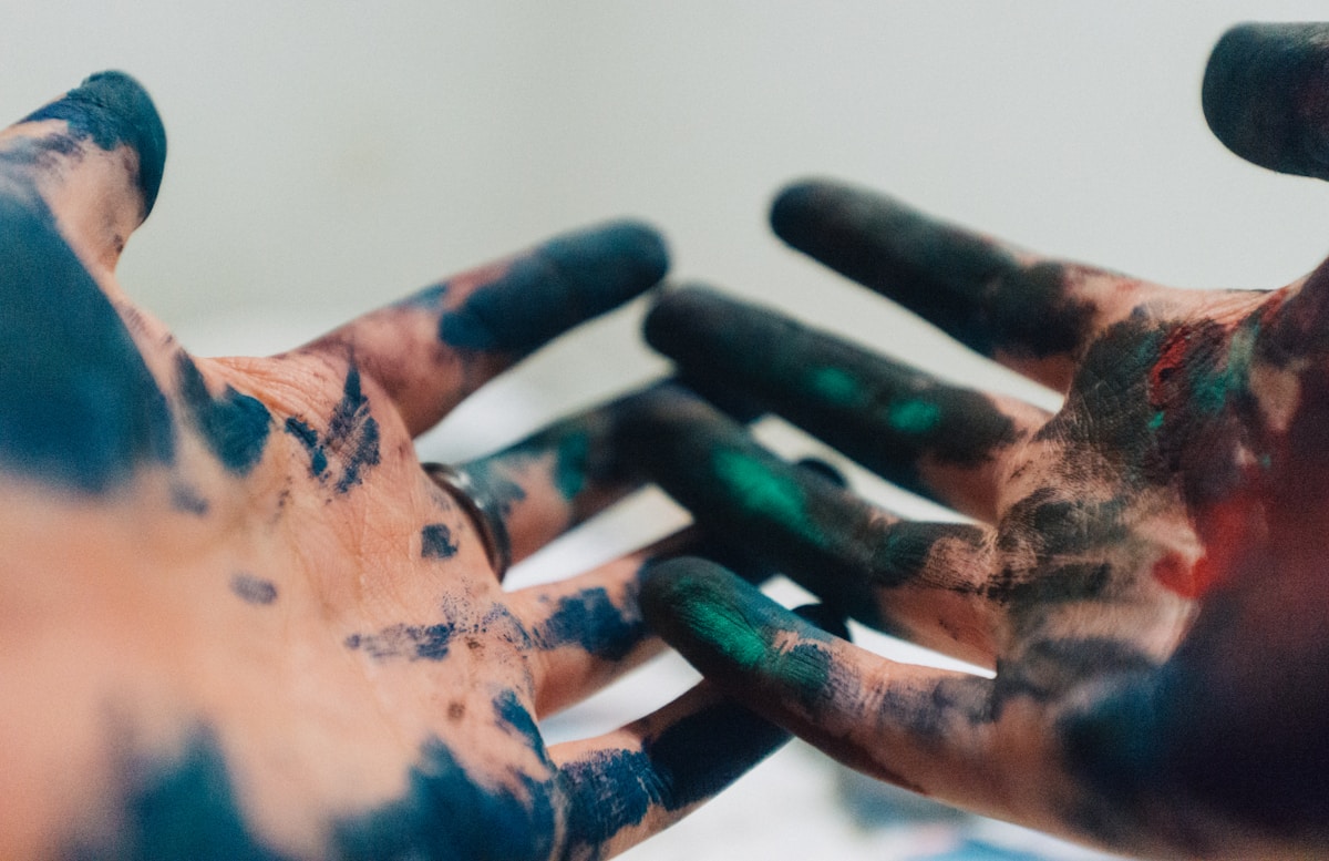 Mains peintes de couleurs vives et abstraites.