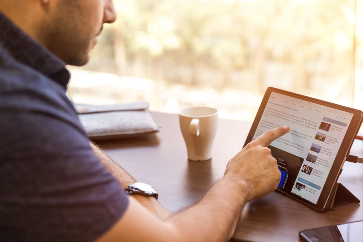 Un homme tenant une tablette numérique.