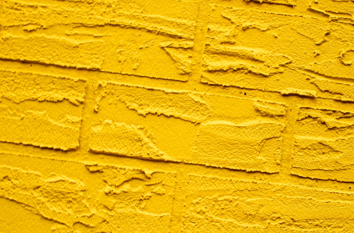 Yellow, textured surface resembling brick.