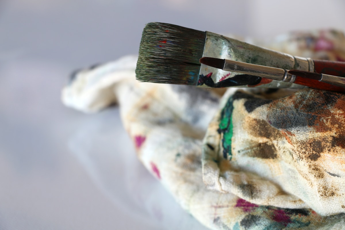 Pinceau de peinture sur toile colorée et texturée.