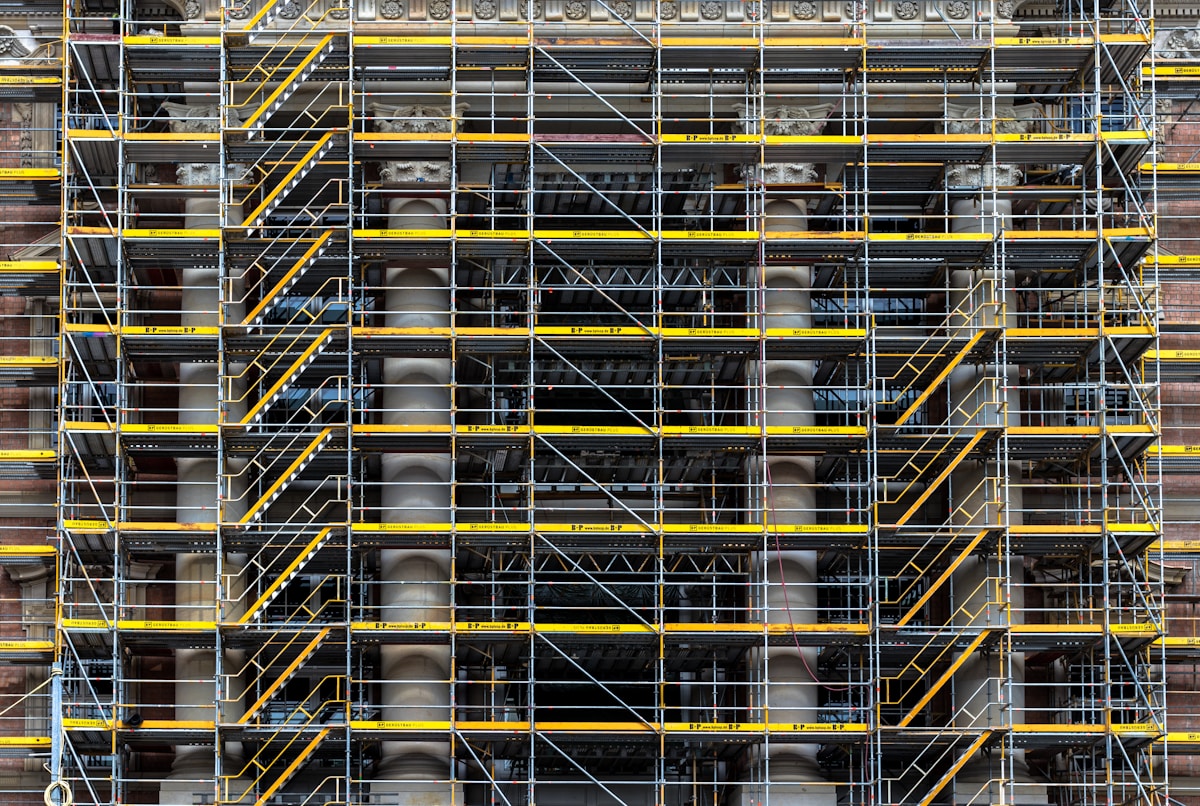 Échafaudage métallique complexe avec des barres jaunes et noires.