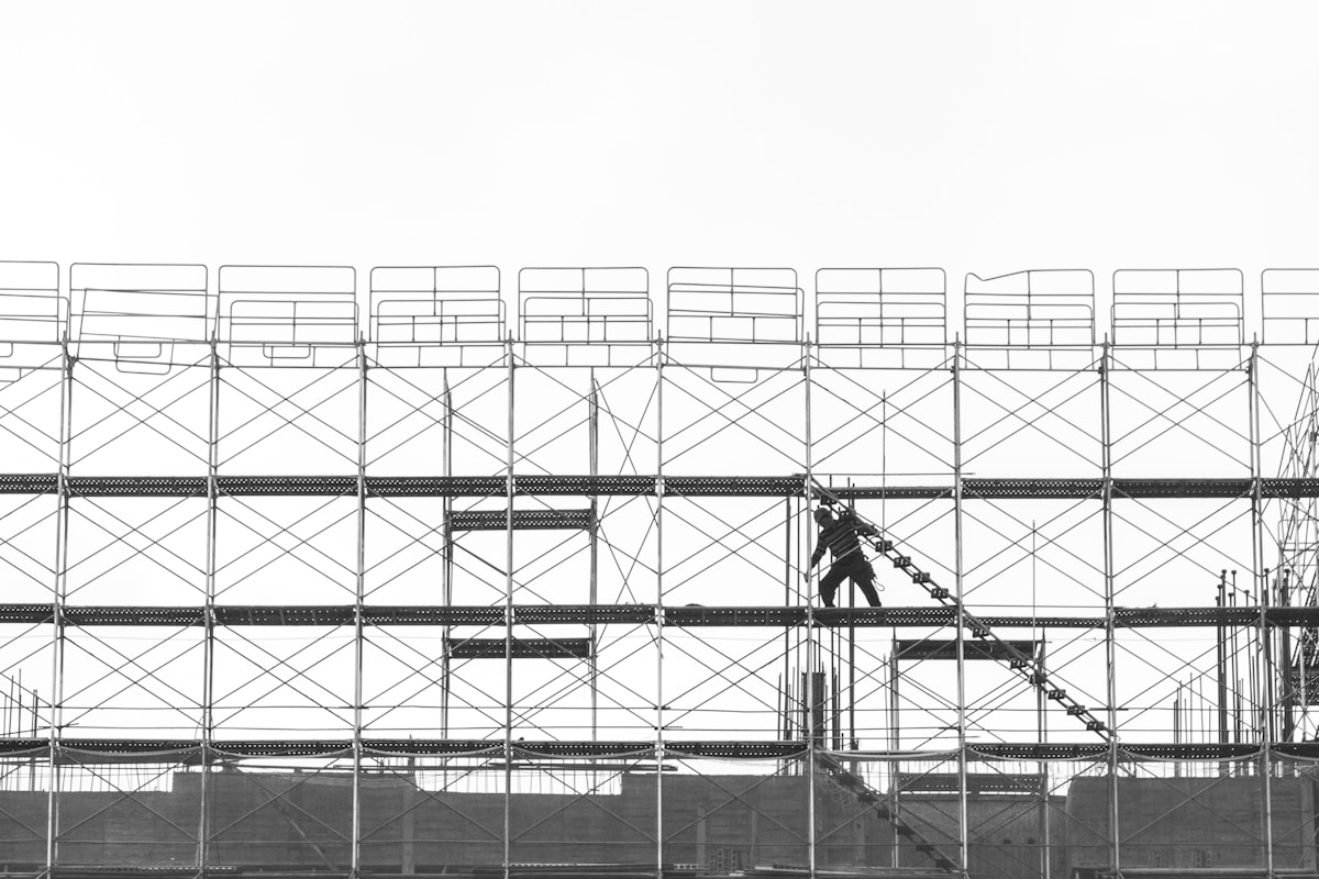 Échafaudage complexe avec un travailleur sur une structure en acier.