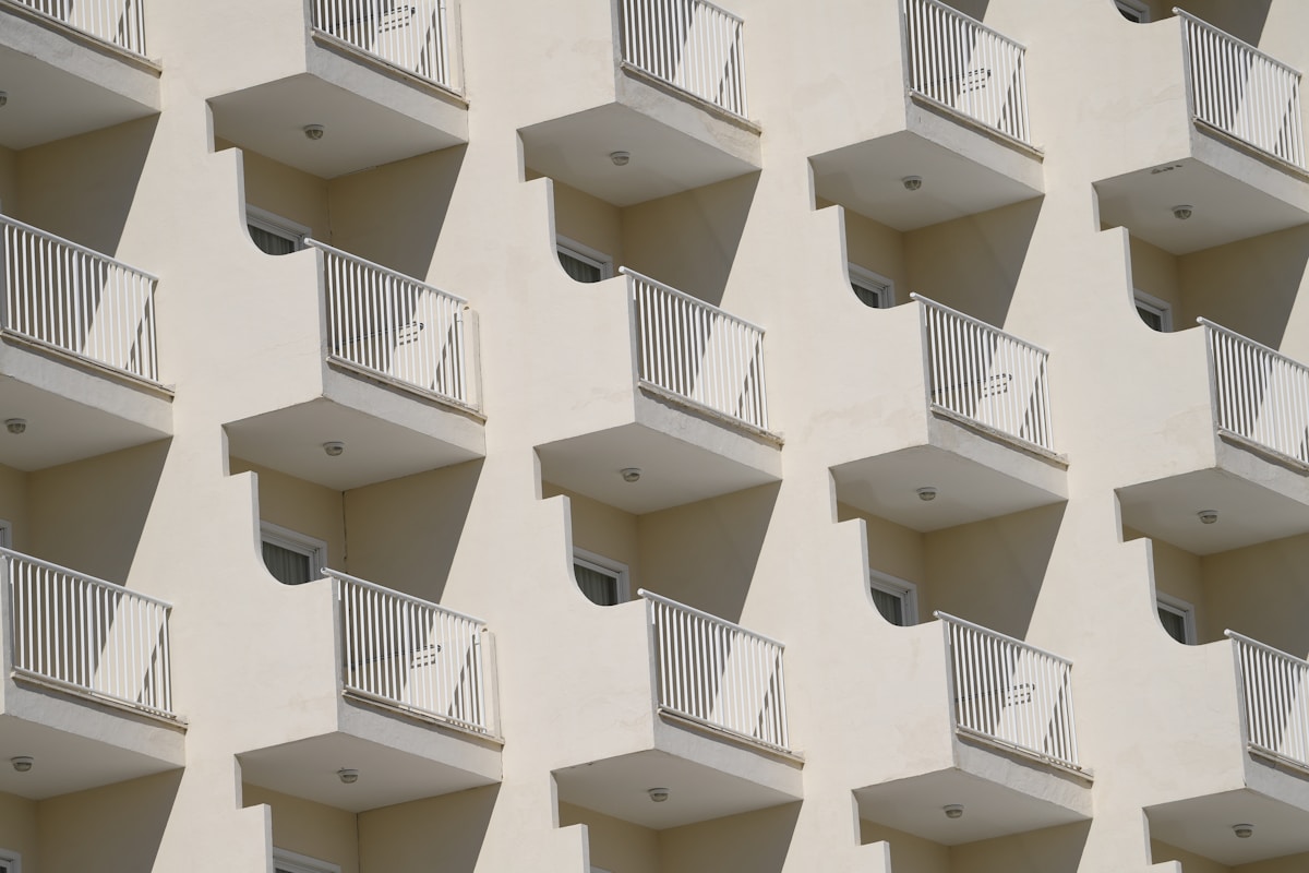 Immeuble résidentiel avec balcons et garde-corps blancs.