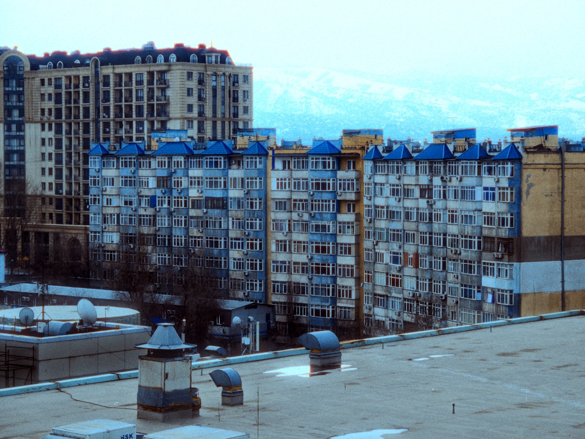 Immeuble résidentiel avec toits bleus, fenêtres et balcons.