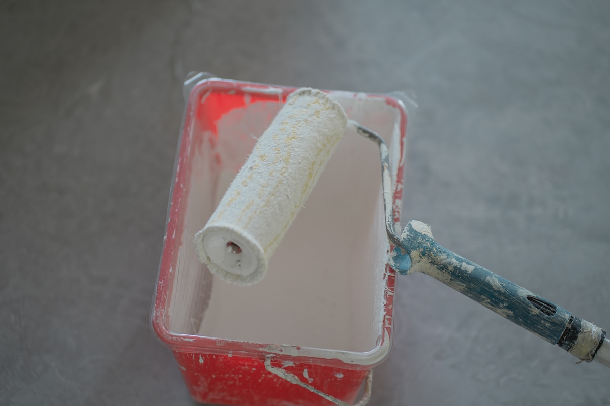 Rouleau de peinture dans un plateau de peinture rouge.