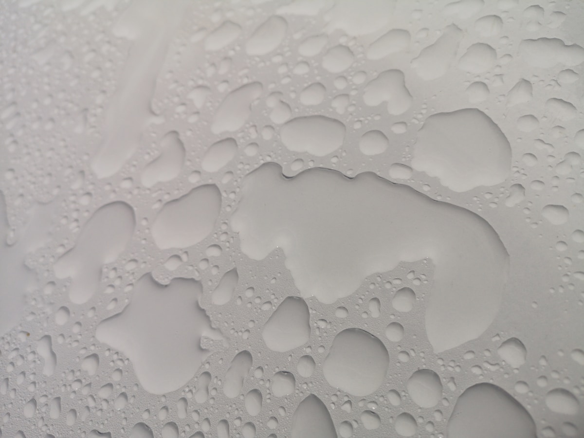 a close up of water drops on a white surface