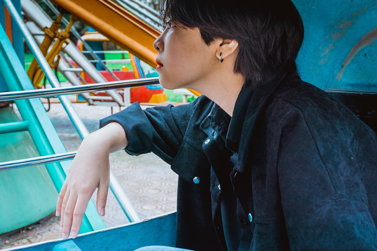 boy in black jacket sitting on blue chair