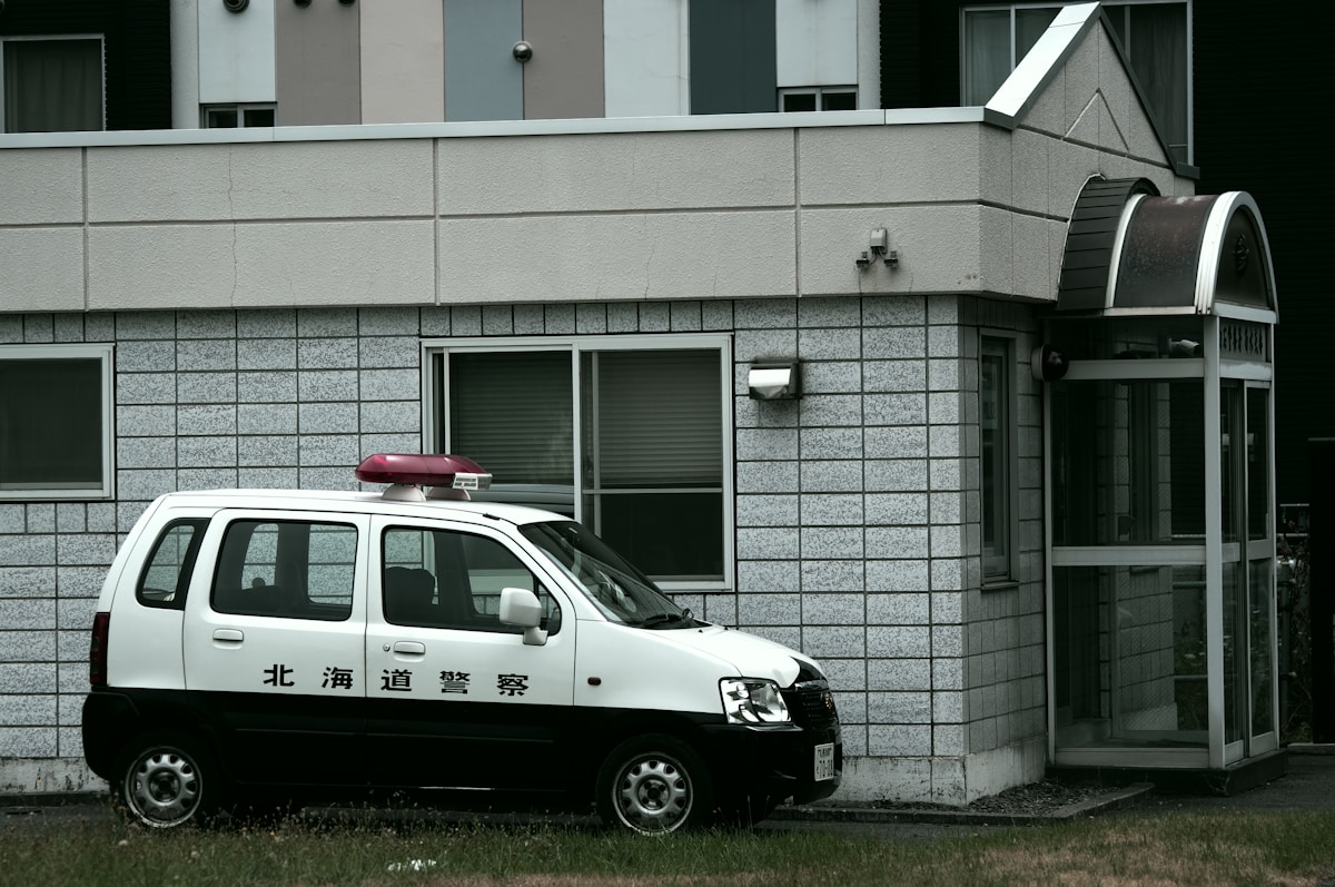 white and black volkswagen t-2 parked beside white concrete building during daytime