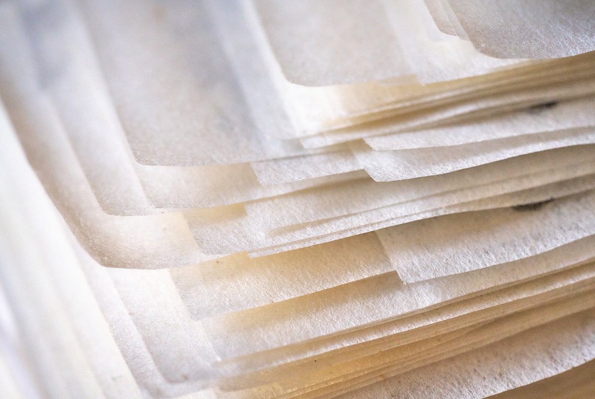 Feuilles de papier translucides empilées avec des ombres et des reflets.