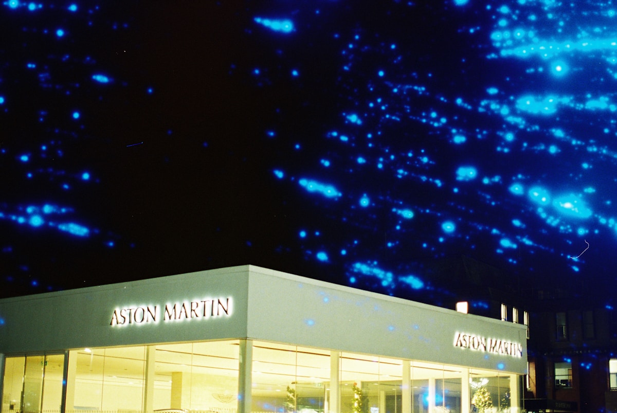 Aston martin dealership at night with blue lights