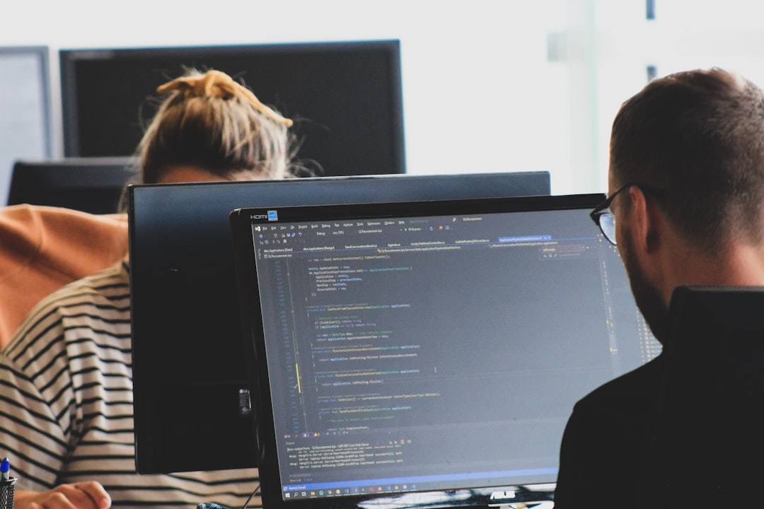 "Developer reviewing website analytics at dual-monitor workstation, preparing for technical SEO audit readiness"