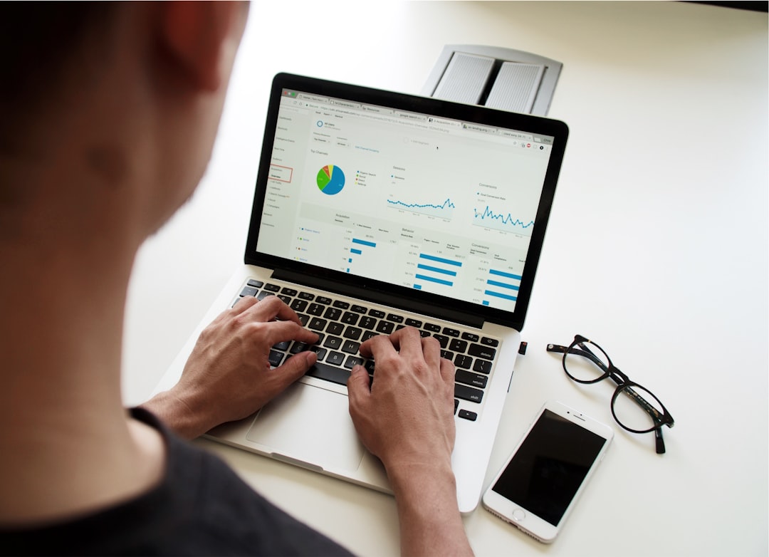 Business professional reviews laptop screen showing SEO metrics and upward trending charts, using an seo roi calculator.