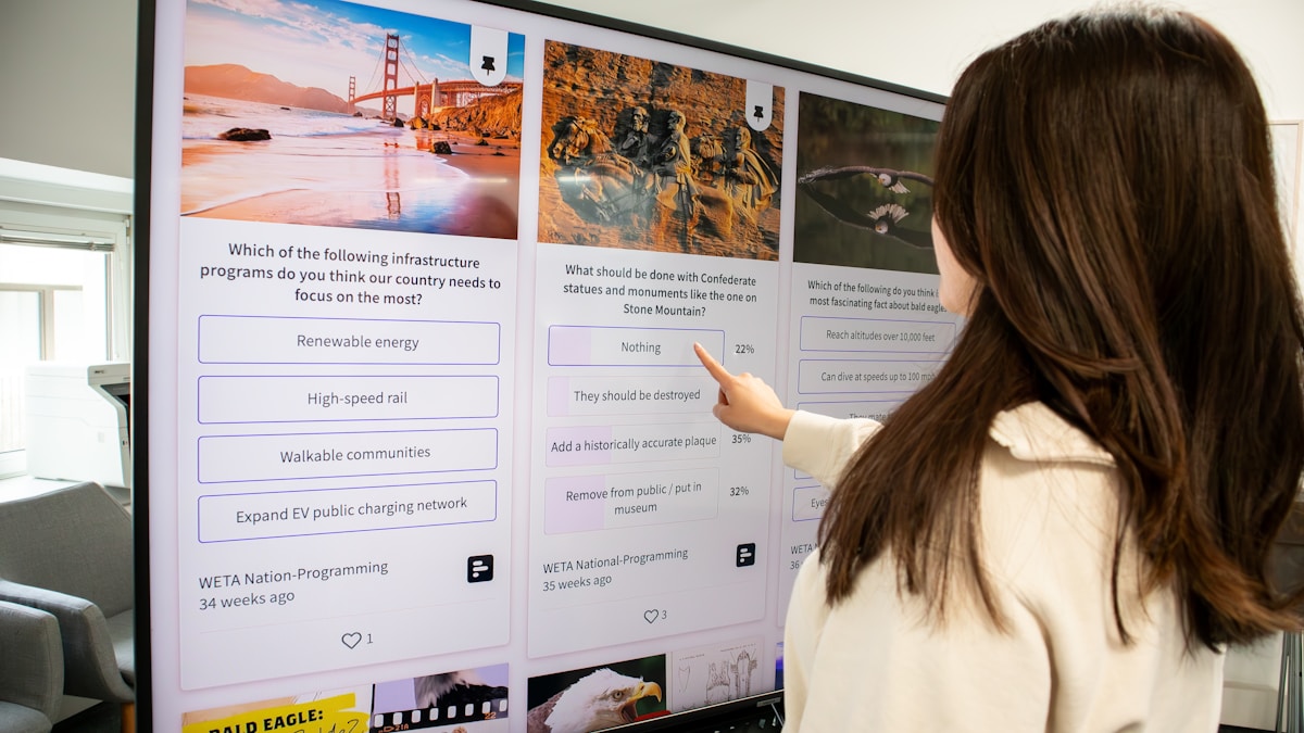 a woman pointing at a poster on a wall