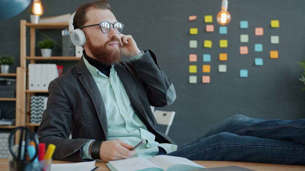 Man with headphones enjoying music at his desk.