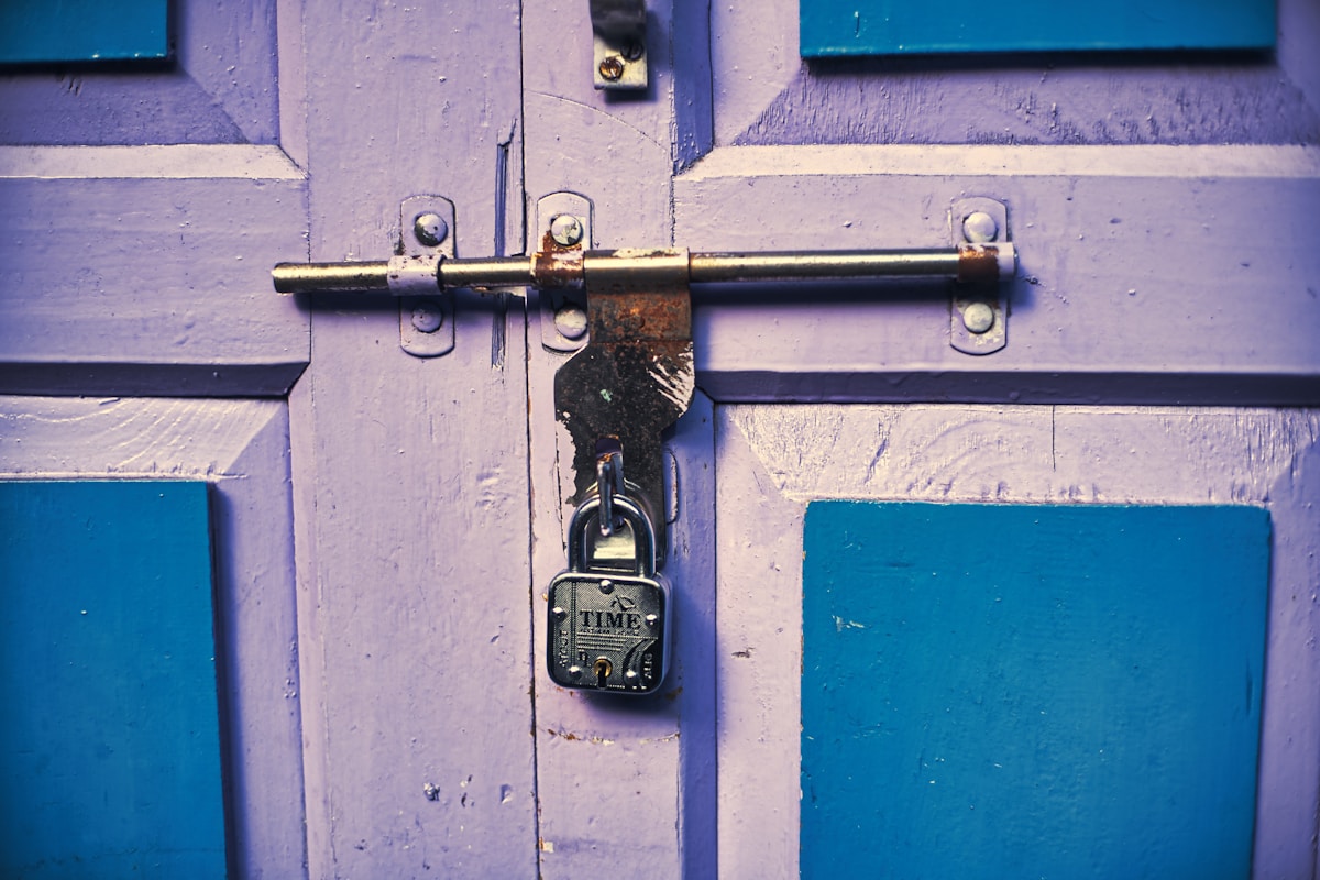 Porte en bois violette avec verrou en métal et cadenas.