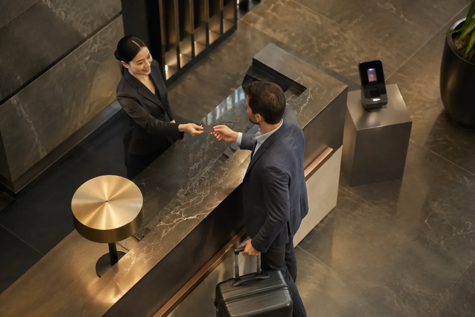 Deux personnes en costume échangent quelque chose dans un hall d'entrée élégant.