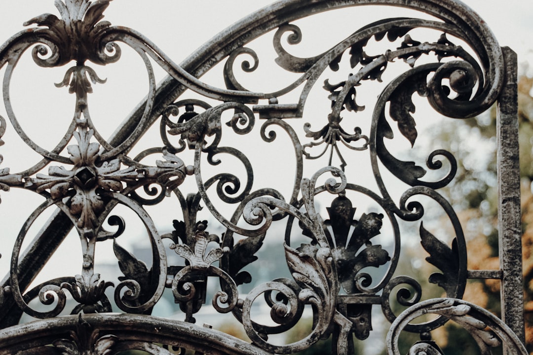 "Clôture en fer noir avec neige blanche, exemple de restauration ferronnerie ancienne bâtiment."