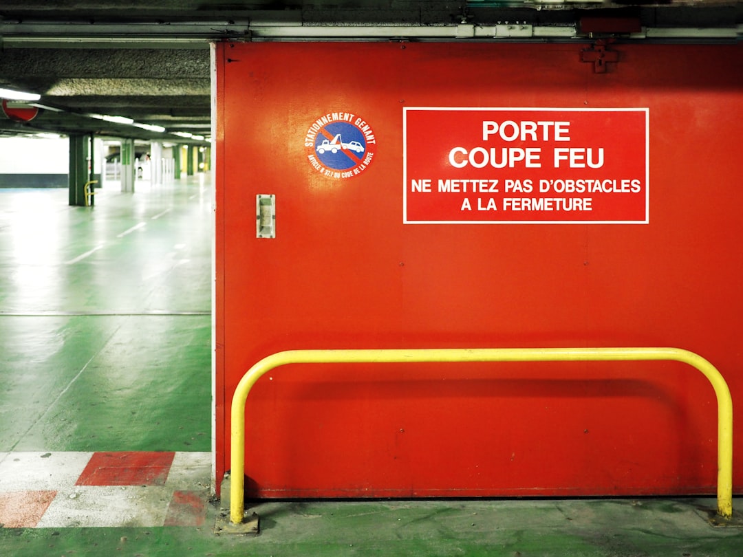 portail métallique coulissant - a red box with a sign on it in a parking garage