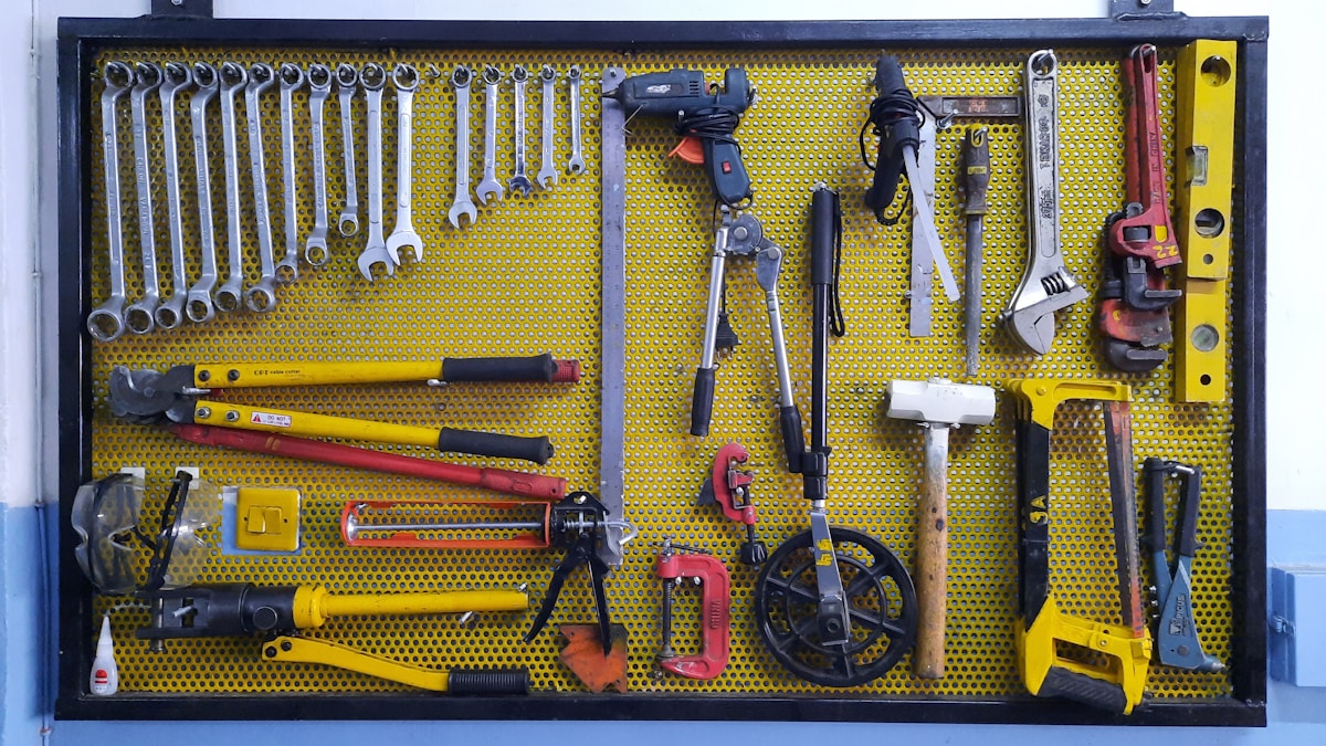 Panneau perforé jaune rempli d’outils d’atelier variés