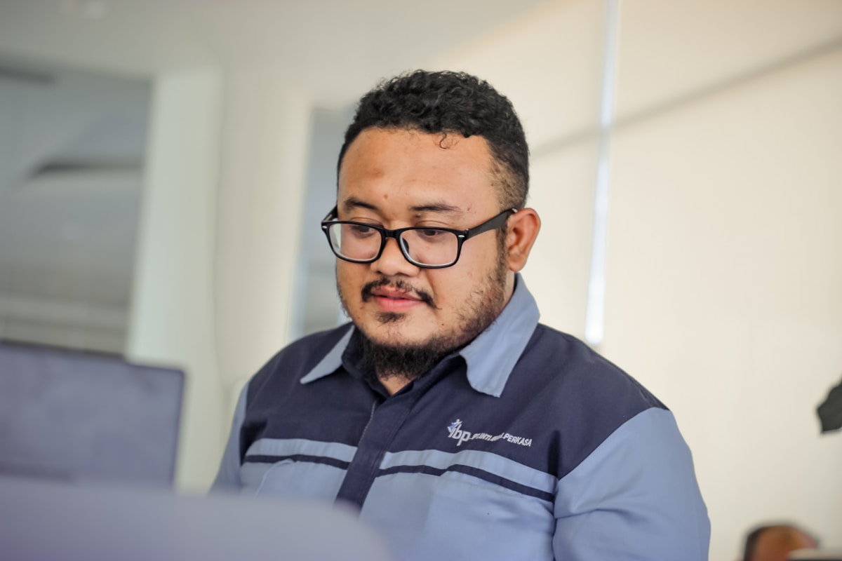 Homme avec des lunettes et une chemise de travail dans un bureau.