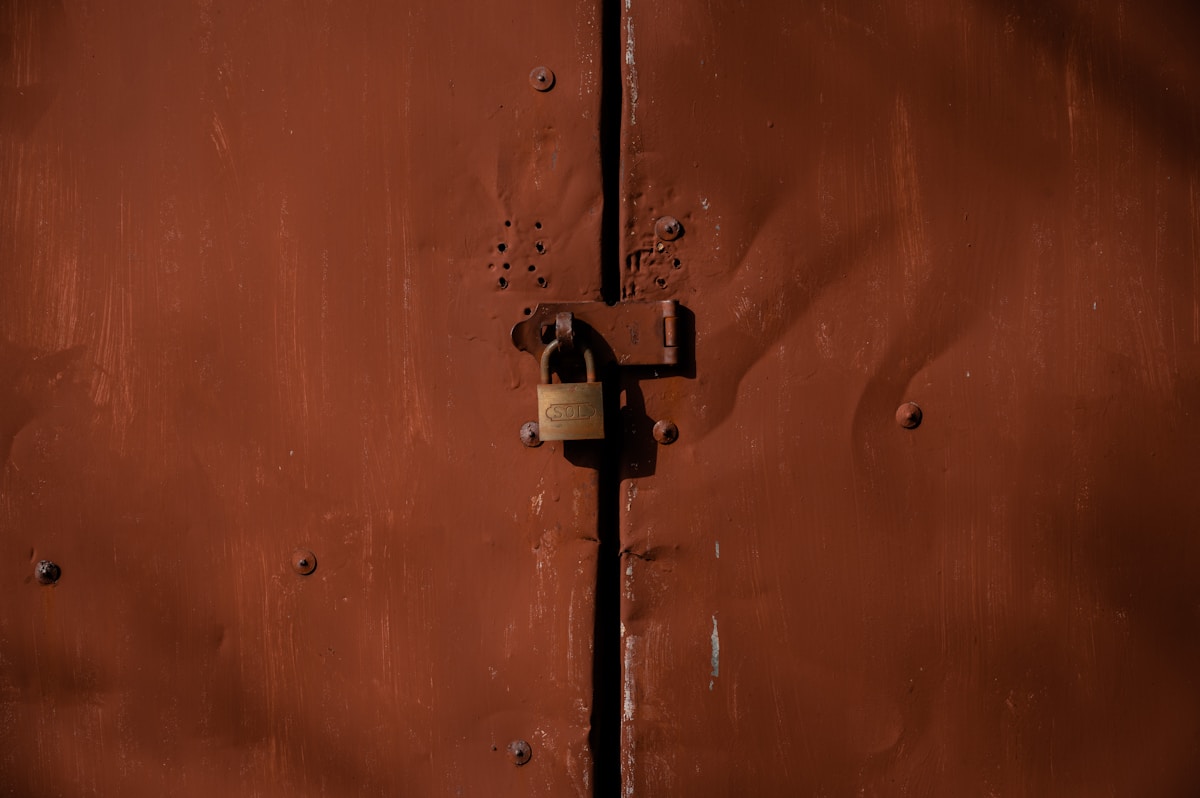 Porte en bois rouillée avec un cadenas.