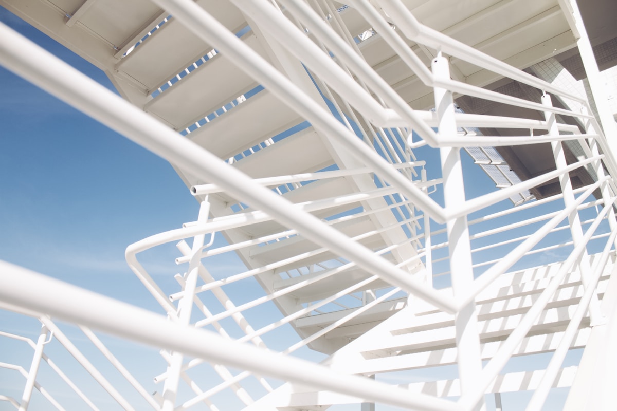 Structure métallique blanche complexe contre un ciel bleu.