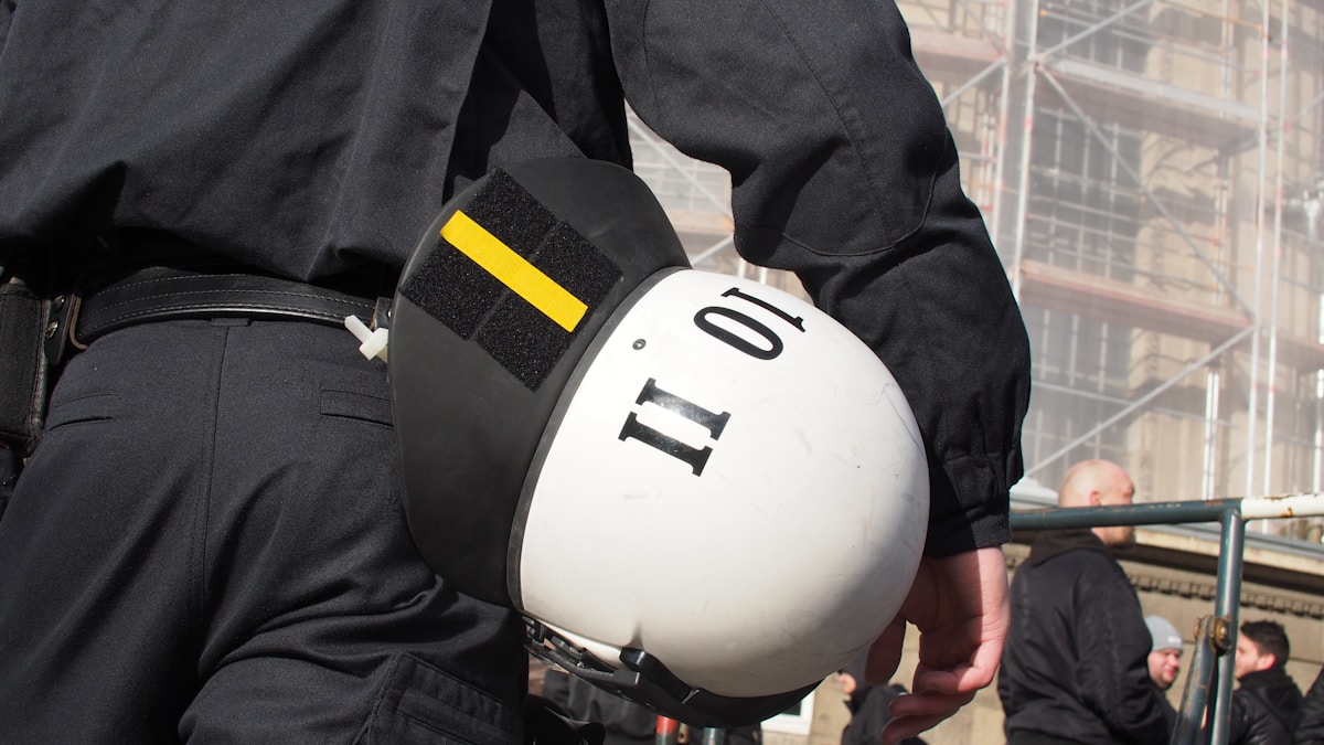 Casque de sécurité blanc avec le numéro 11 sur un travailleur en uniforme noir.