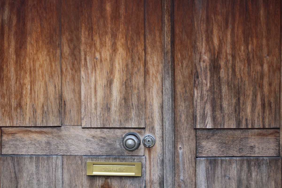 Porte en bois rustique avec poignée et boîte aux lettres.