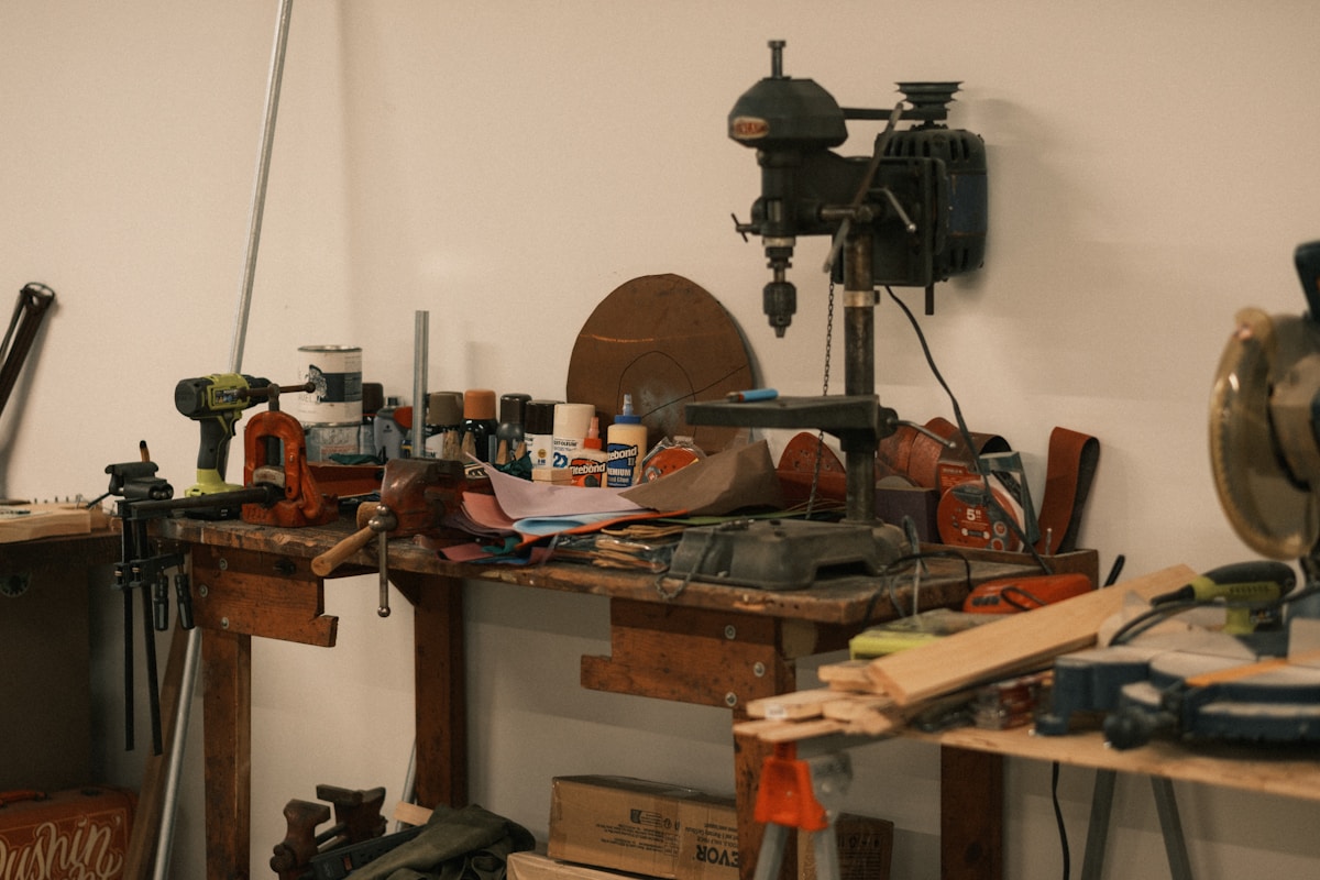Établi d'atelier encombré d'outils et de matériaux de bricolage.