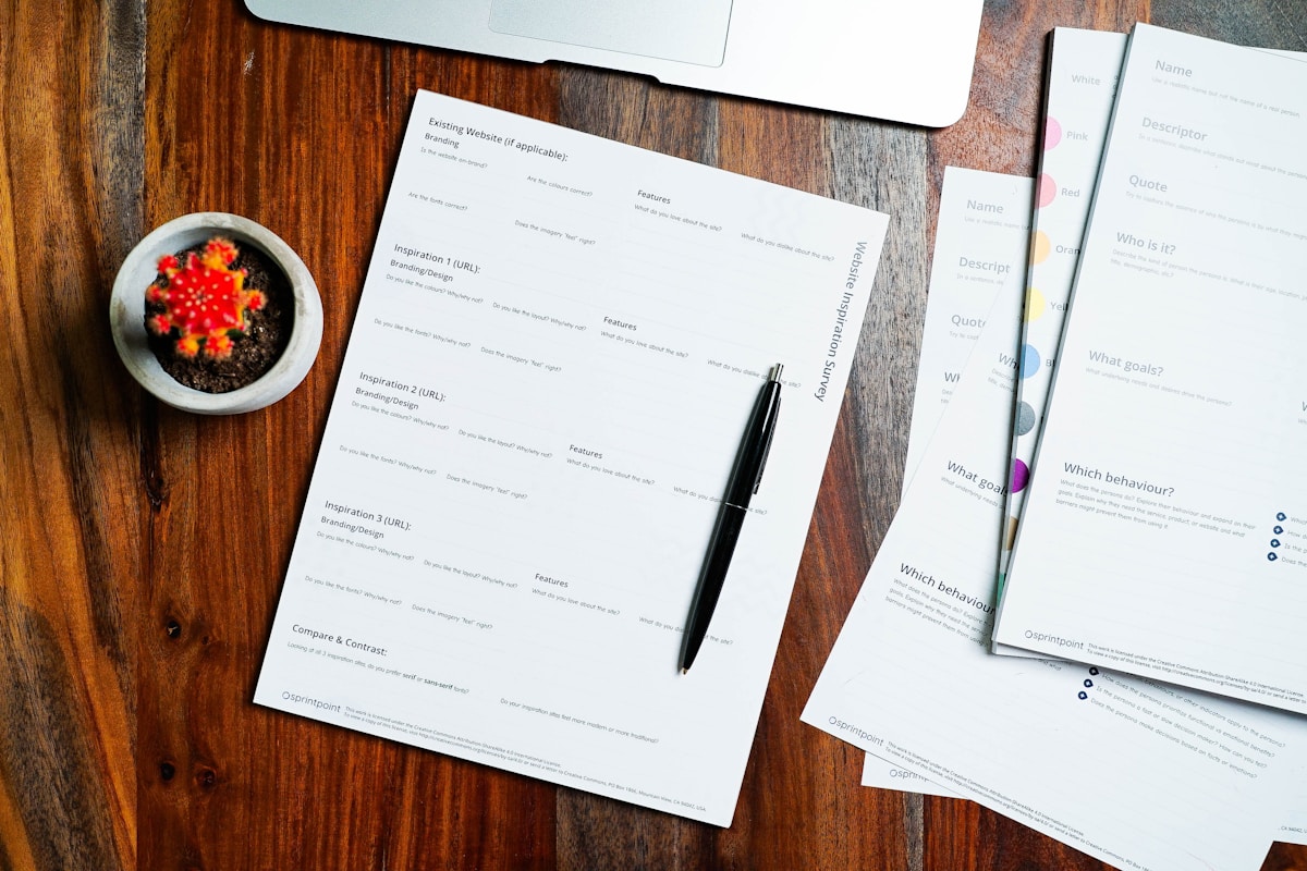 Formulaire d'évaluation de site web sur un bureau en bois avec un stylo et une plante en pot.