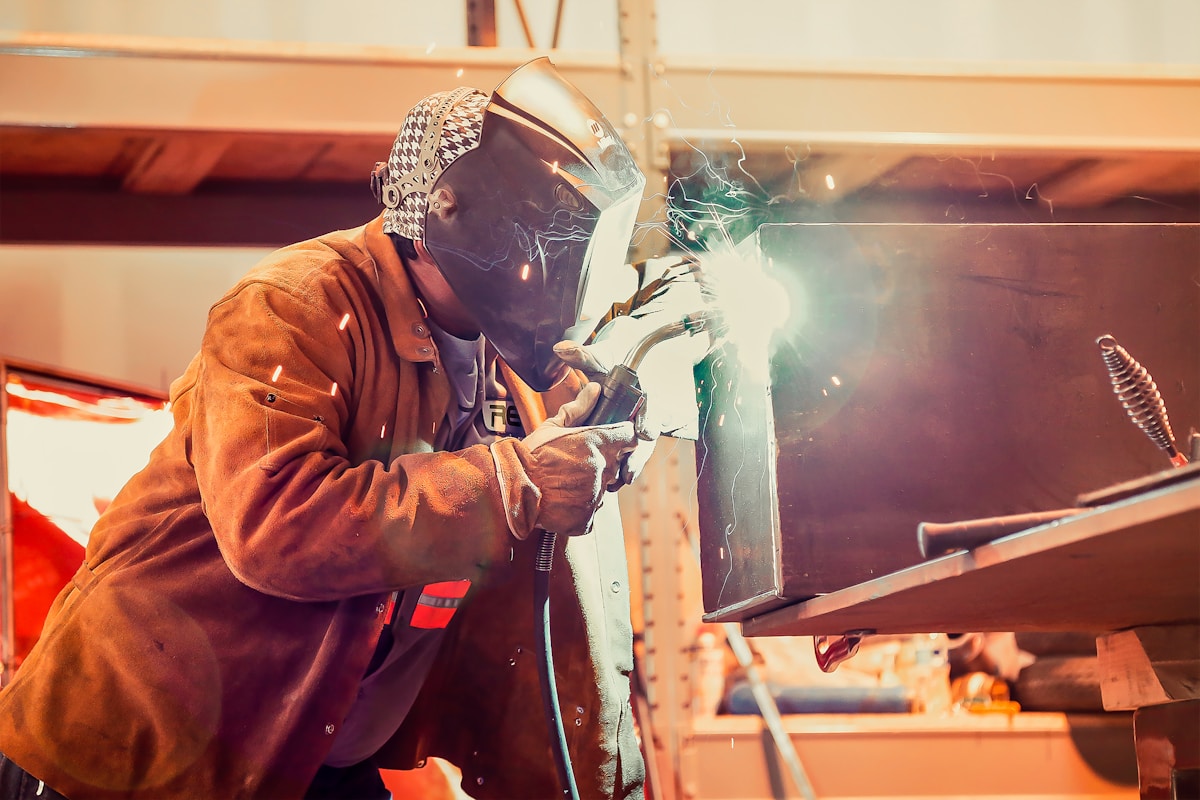 Soudeur travaillant avec un équipement de protection dans un atelier.