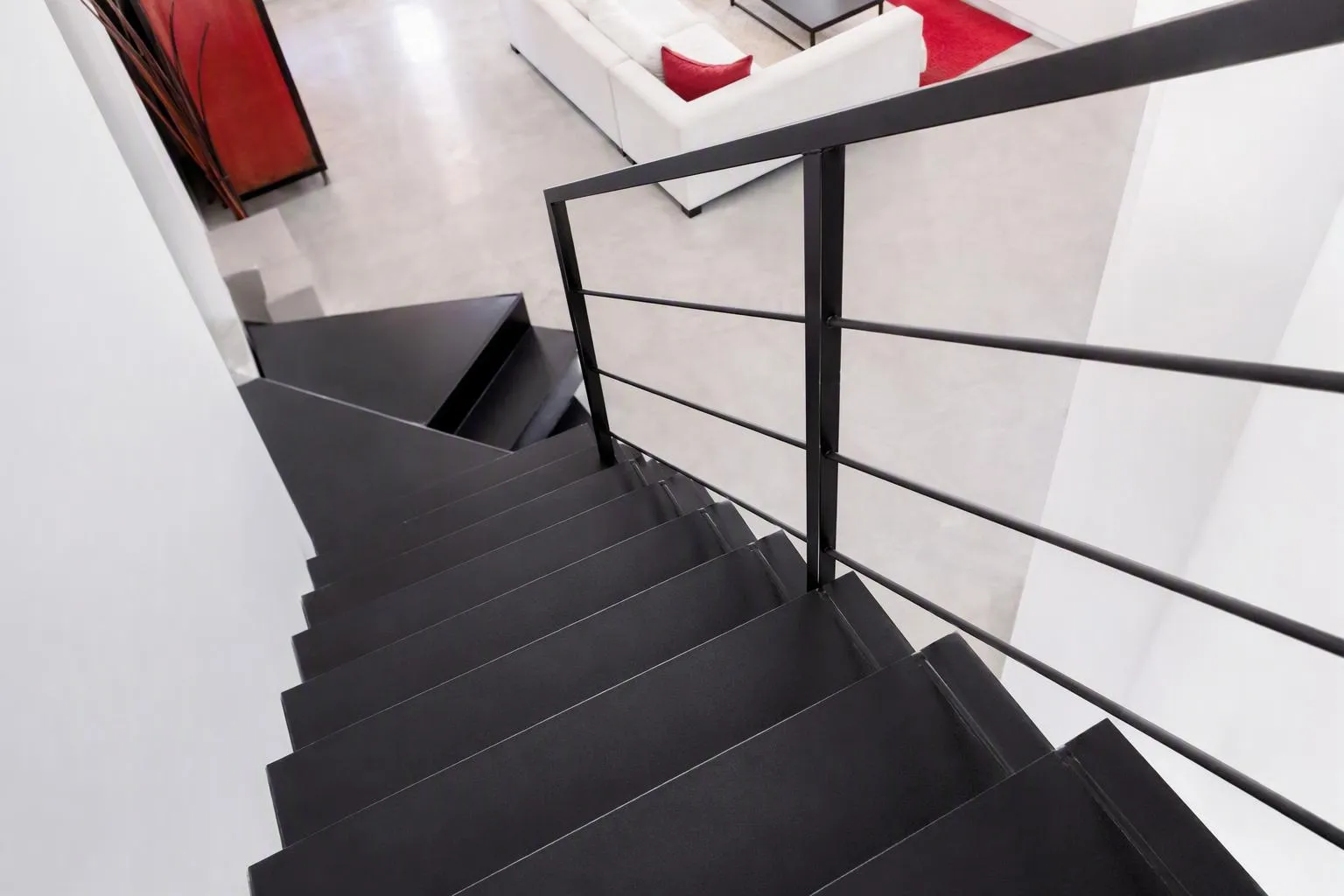 Escalier noir moderne avec rambarde dans un intérieur élégant.