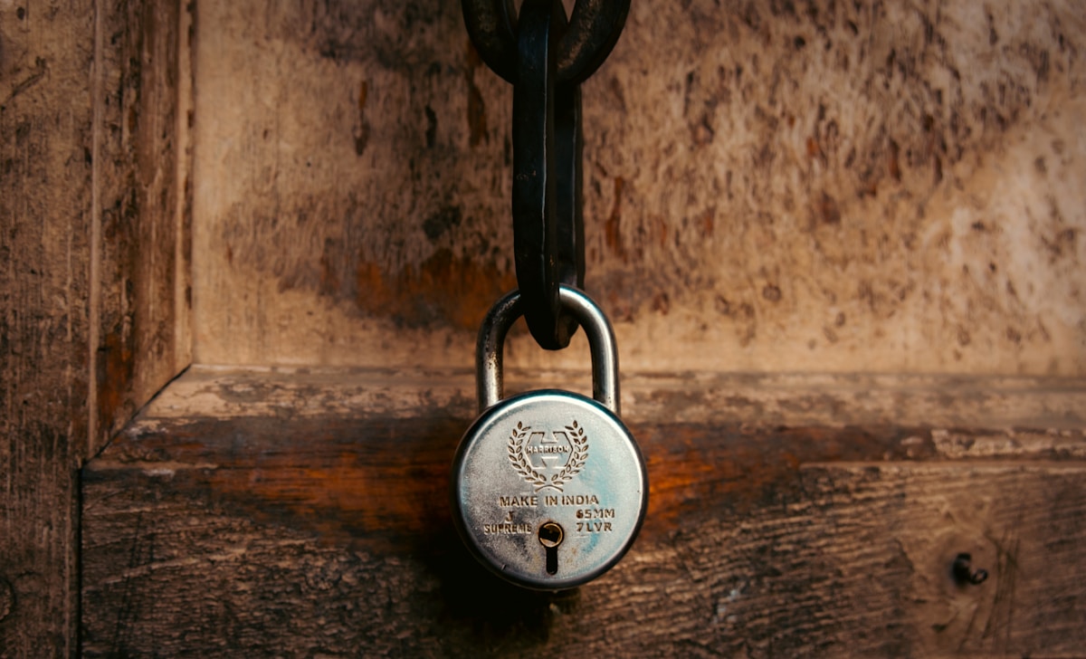 Cadenas en métal avec inscription "Made in India" sur un mur en bois.