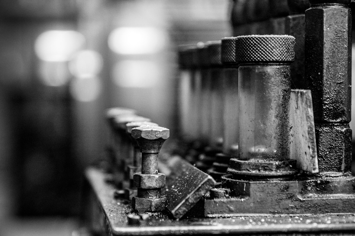 Outils de travail anciens, mécaniques et rouillés dans un atelier sombre.