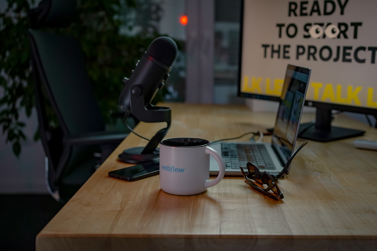 Bureau de travail avec équipement informatique et tasse de café.