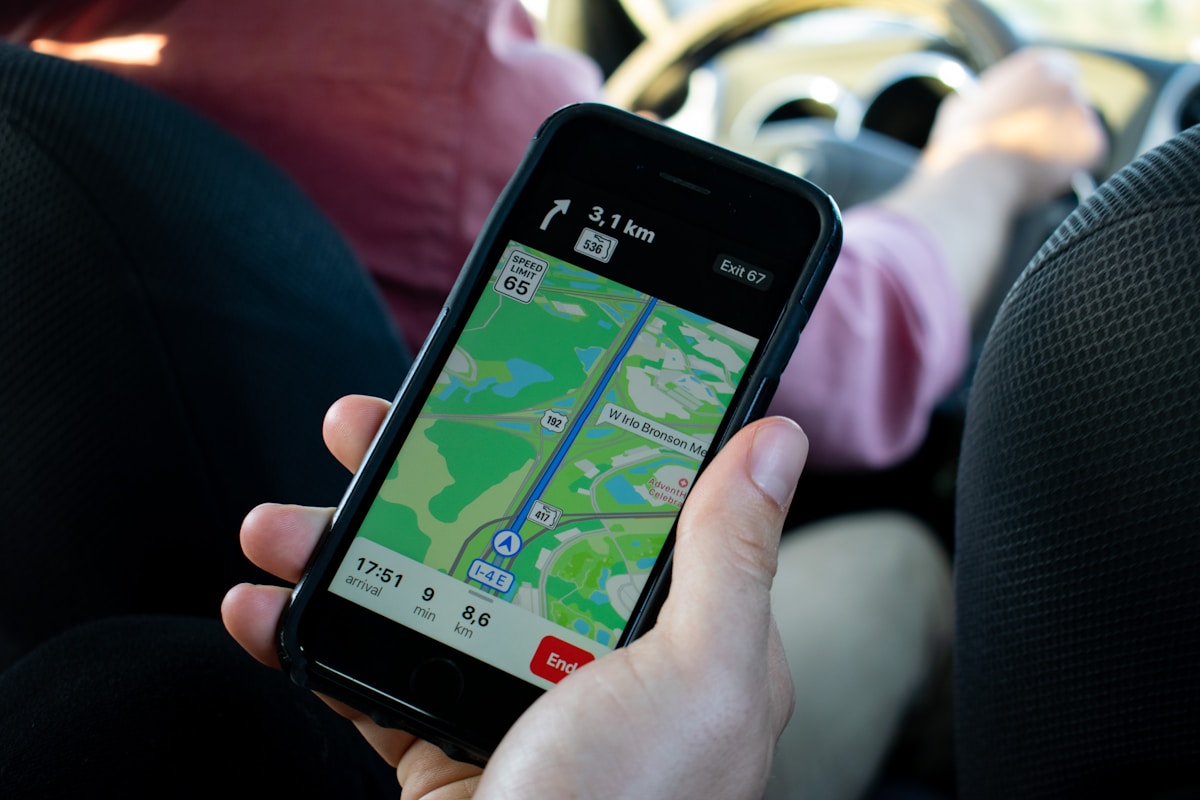 Smartphone affichant une application de navigation avec une carte et des informations de trajet.