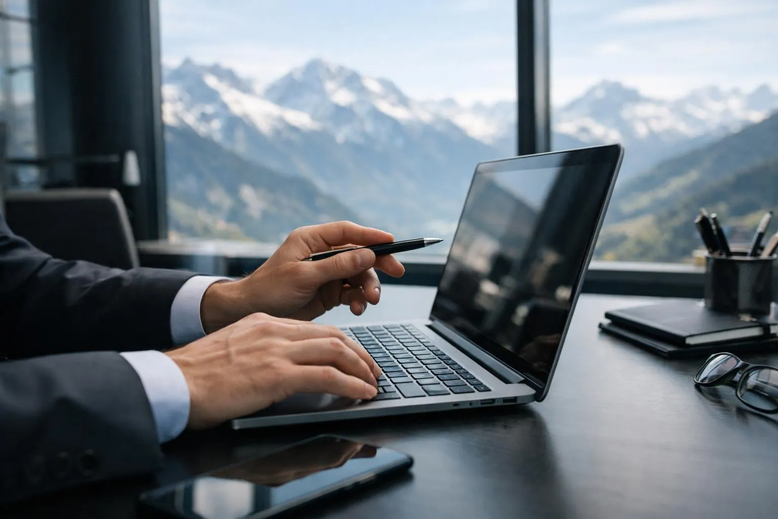 Homme d'affaires travaillant sur ordinateur portable avec vue panoramique sur les montagnes.