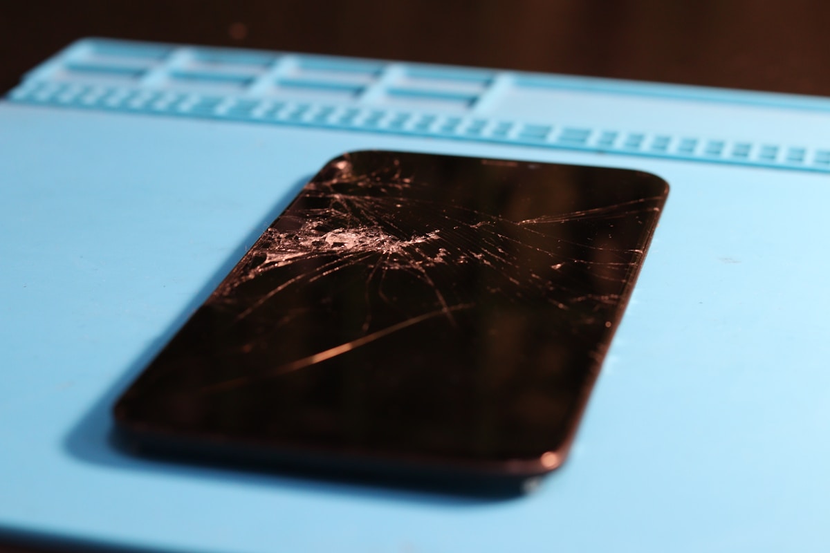 Écran de téléphone portable cassé avec de multiples fissures.