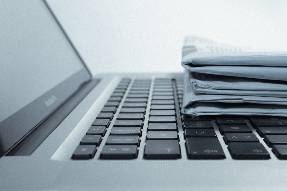 Ordinateur portable avec des documents empilés sur le clavier.