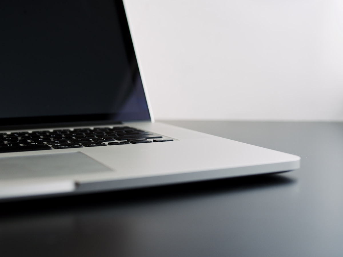 Ordinateur portable noir sur surface blanche.